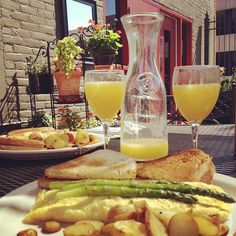 the meal is prepared and ready to be eaten on the outdoor table with two glasses of orange juice