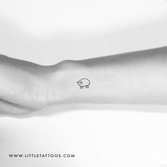 a small pig tattoo on the left inner arm and wrist is shown in black and white