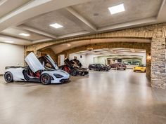 two cars are parked in a large garage