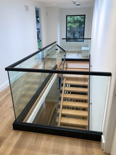 an empty room with wooden floors and glass railings