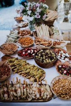 a table topped with lots of different types of food on wooden spoons and plates