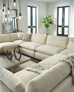 a living room with a large sectional couch and coffee table in front of the window