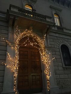 an entrance to a building decorated with christmas lights