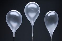 three clear glass objects on black background with one being blown by the wind and the other blowing in the air