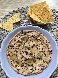 a bowl of hummus and tortilla chips on a table