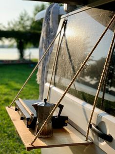 a tea pot is sitting on a window sill in front of a grassy area