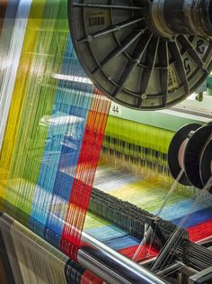 a machine that is spinning yarn on it's sides and the colors are multicolored