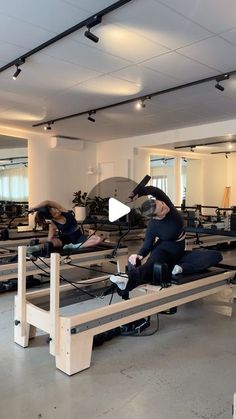 two people are doing pivots on benches in a gym while another person watches