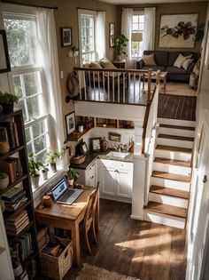 a living room filled with furniture and a laptop computer on top of a wooden table