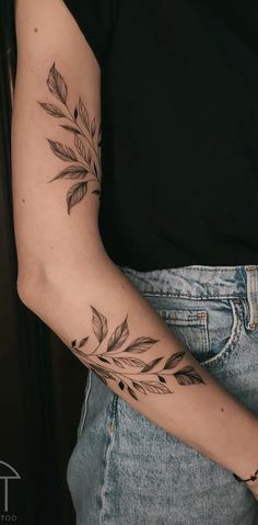 a woman's arm with leaves on it