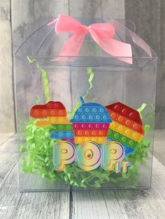 a clear box filled with legos and lettuce on top of a wooden table