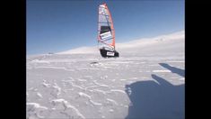 a person riding a wind sail on top of snow covered ground