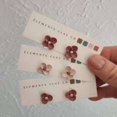 a person holding three flower shaped business cards