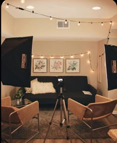 a camera set up in front of a couch with lights on the wall behind it