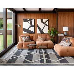 a living room filled with furniture and large windows