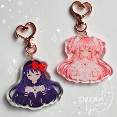 two keychains with anime characters on them, one is pink and the other is purple