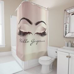 a bathroom with a shower curtain that has an image of a woman's eyes on it