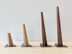 three pieces of wood sitting on top of each other in front of a white wall