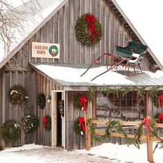 a building with wreaths and decorations on the front door is decorated for christmas time