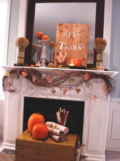 a mantel decorated with pumpkins and candles