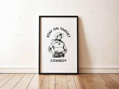 a black and white framed poster with the words stay on target cowboy in front of it