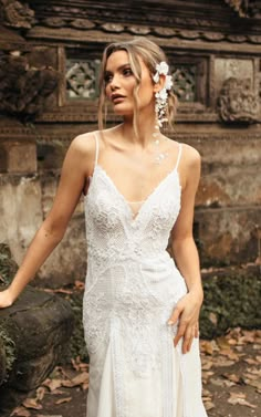 a woman in a white wedding dress posing for the camera with her hand on her hip