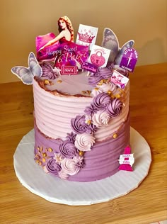 a birthday cake with purple frosting and cards on top, sitting on a wooden table