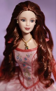 a doll with long red hair wearing a pink dress and gold necklace on it's neck