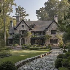 a large stone house surrounded by lush green trees