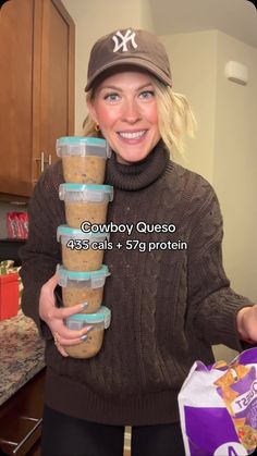 a woman holding a stack of food in her hands