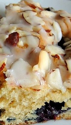 a piece of cake with icing and nuts on it sitting on a white plate