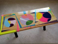 a table that has been made out of wood and painted with different colors on it