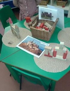 a green table topped with lots of wooden blocks