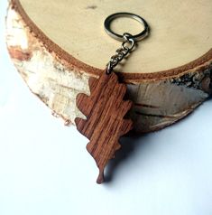 a wooden keychain is sitting on top of a piece of wood that has been carved into the shape of a tree