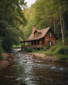 a cabin in the woods with a river running through it and a porch on top