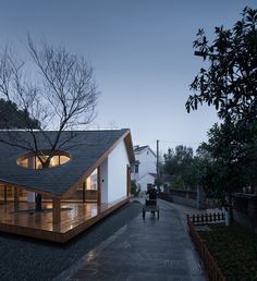 a person walking down a sidewalk next to a building with a roof made of wood