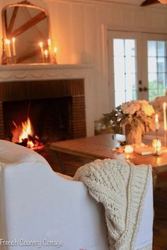 a living room filled with furniture and a fire place next to a fireplace covered in candles