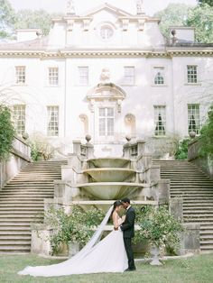 a bride and groom standing in front of a large building with steps leading up to it