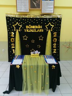 the table is set up for an event with black and gold decorations, stars on it