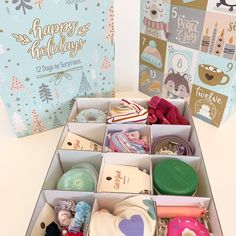 a box filled with lots of different items next to a greeting card and gift bag