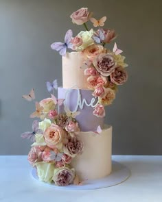 two tiered wedding cake with flowers and butterflies on top