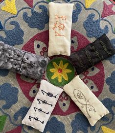 four pairs of socks with different designs on them sitting on top of a colorful rug