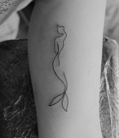 a woman's leg with a tattoo on it that is shaped like a mermaid