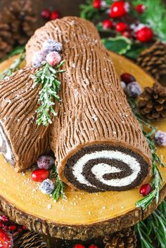 a log cake decorated with pine cones and berries