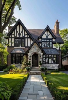 a large house with lots of windows in the front yard and landscaping on both sides