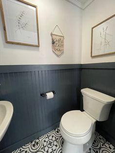 a white toilet sitting in a bathroom next to a sink and a mirror on the wall