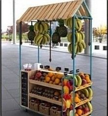 an outdoor fruit stand with bananas and oranges