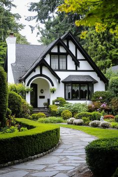 a white and black house surrounded by greenery