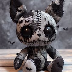 a stuffed animal with black and white designs on it's face, sitting on a table