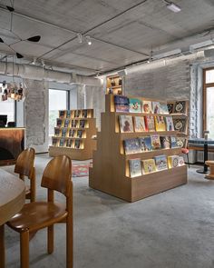 an open book store with many books on the shelves and wooden chairs in front of it